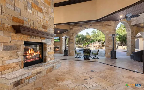 a living room with furniture a fireplace and a dining table with garden view