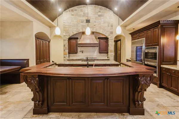 a kitchen with a stove a refrigerator and cabinets