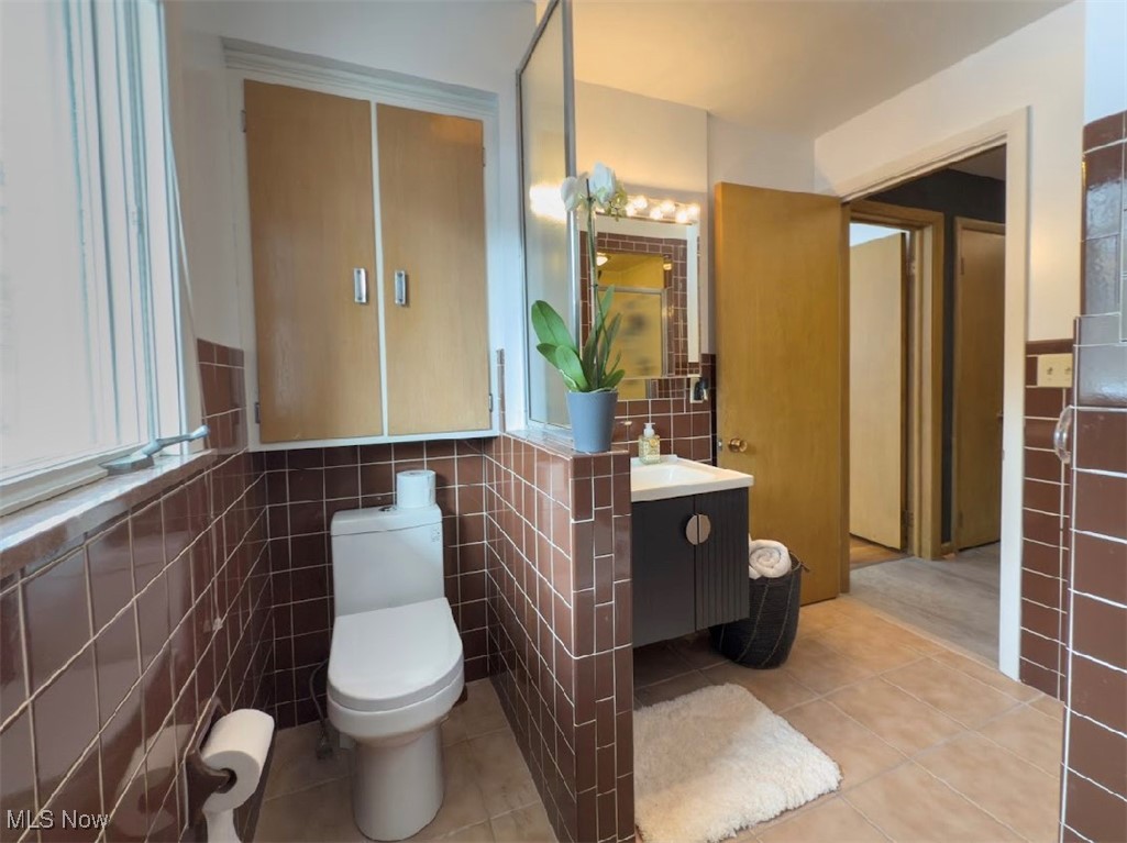 7817 Montello Road Independence, OH 44131 - Photo 19 of 35 Bathroom with tile patterned floors, tile walls, and vanity