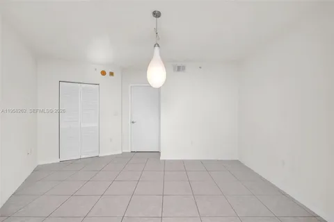 a view of an empty room and chandelier fan