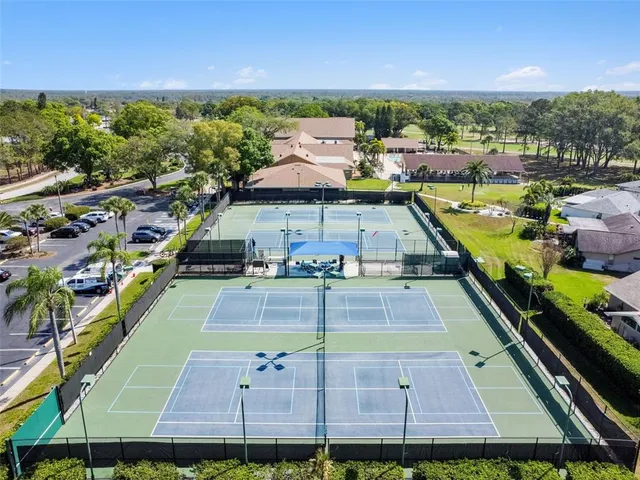 a view of a water fountain and a lawn chairs under an umbrella