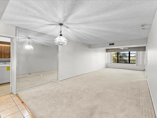 a view of a room with a chandelier fan and windows