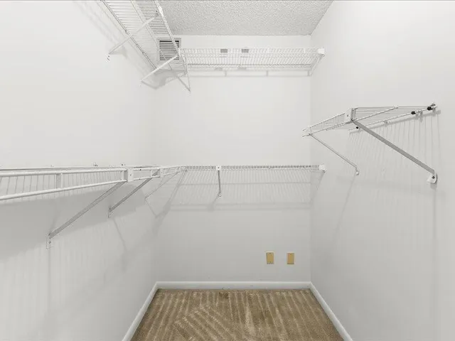 an empty room with a window and a ceiling fan