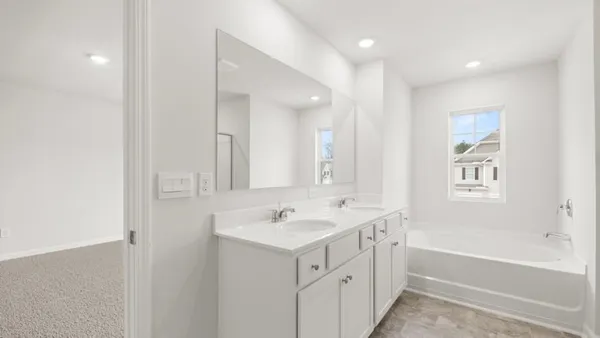 a bathroom with a sink a mirror a vanity and a bathtub