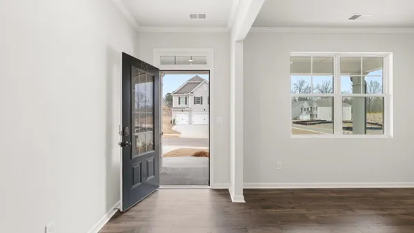 a view of a hallway with wooden floor and a livingroom