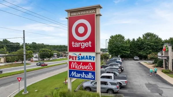 a view of a street with benches and a garden