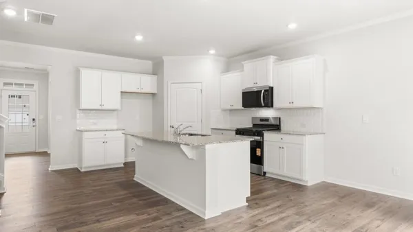 a kitchen with a stove top oven and white cabinets