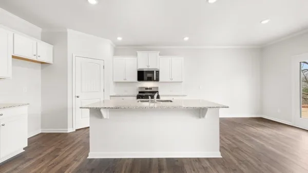 a view of a kitchen with cabinets stainless steel appliances and wooden floor