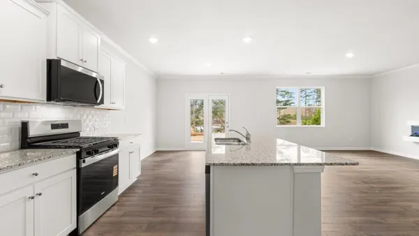 a kitchen with granite countertop a stove top oven microwave and cabinets