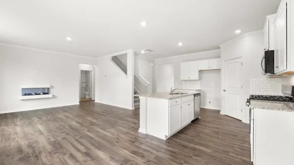 a large kitchen with stainless steel appliances granite countertop a stove a sink and a refrigerator