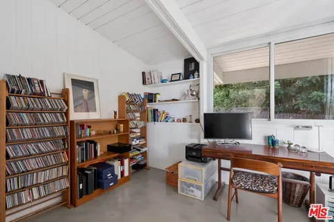 a view of a workspace with furniture and a window