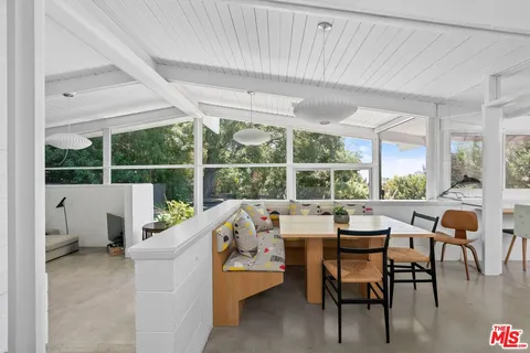 a dining room with furniture and a large window