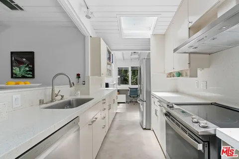 a kitchen with sink stove and cabinets