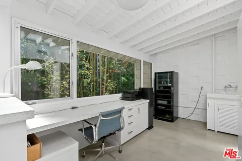 a view of a workspace with furniture and window