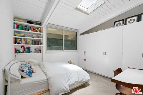 a bedroom with a bed and a book shelf