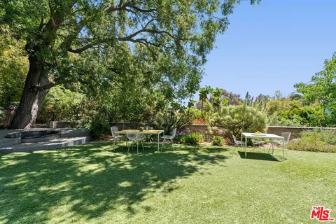 a backyard of a house with table and chairs