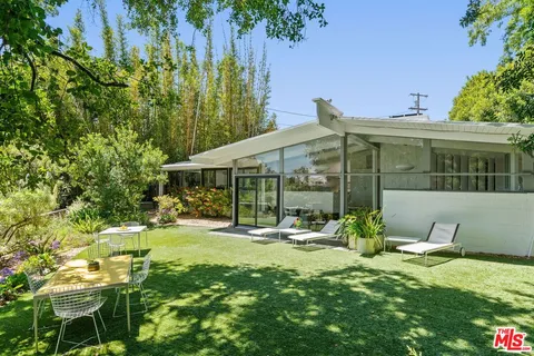 a view of a house with backyard porch and sitting area