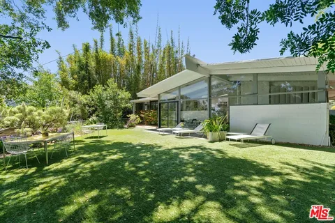 a view of a house with pool and sitting area
