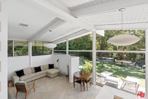a living room with furniture and a floor to ceiling window