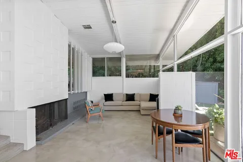 a living room with furniture a table and a large window