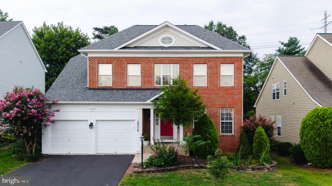 Charming brick home with lush greenery.