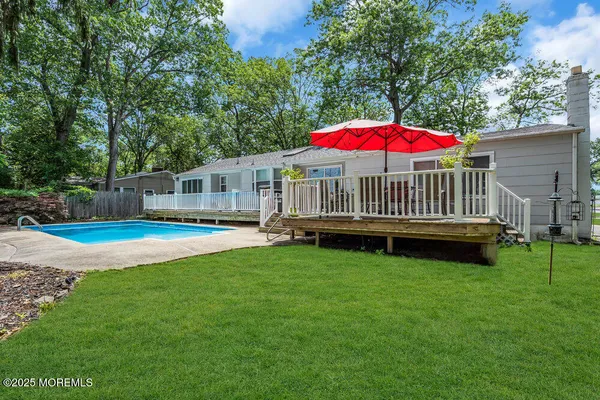 a view of a house with a yard and deck