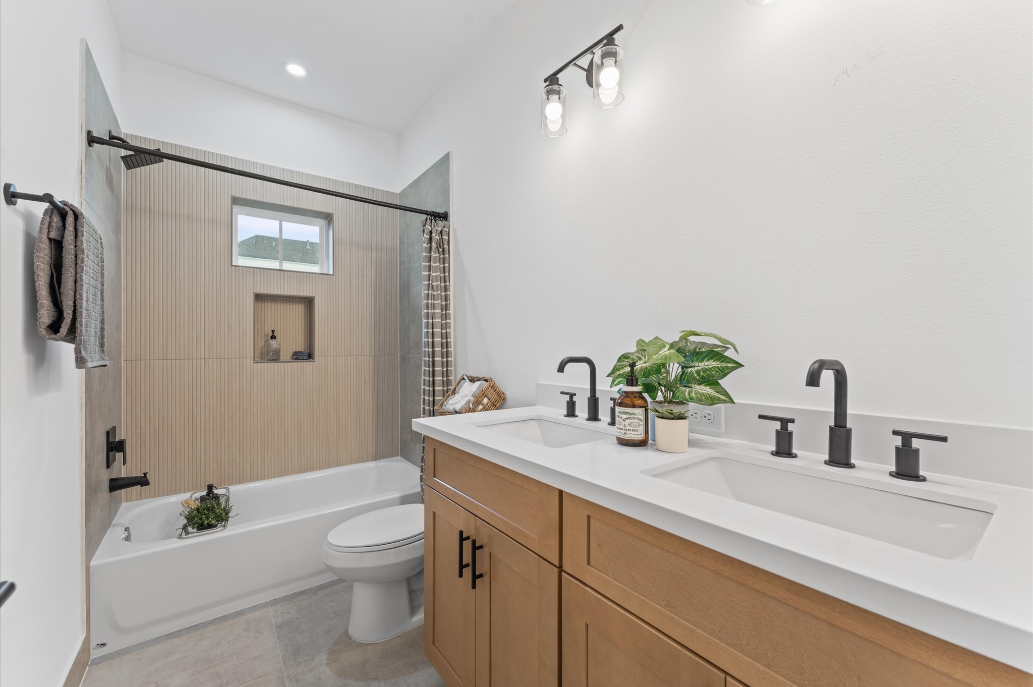 3002 Jensen Drive Houston, TX 77026 - Photo 22 of 42 Beautifully appointed Jack and Jill bathroom nestled between two secondary bedrooms on the first floor, designed to balance style and functionality. Each bedroom enjoys private access to the shared space, which features a sleek tub-shower combo, perfect for both quick rinses and relaxing soaks. Contemporary tilework, dual vanities, and bright lighting add modern appeal, while thoughtful layout enhances privacy and ease of use.