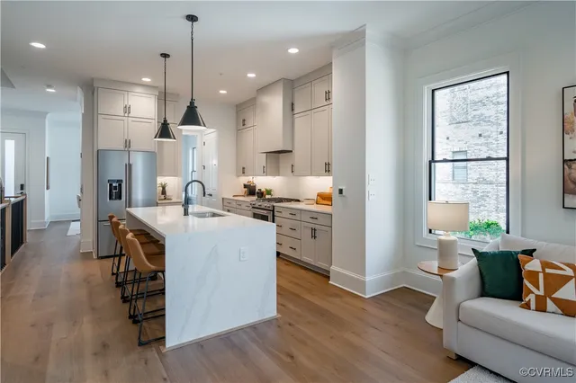 a kitchen with kitchen island stainless steel appliances a stove a sink a refrigerator and cabinets