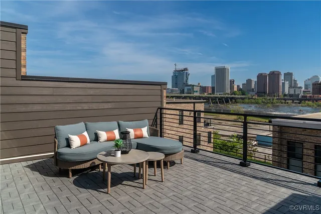 a roof deck with a table and chairs and potted plants