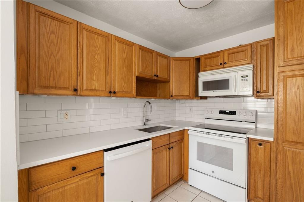 2941 Caldwell Road Northeast, Unit B4 Brookhaven, GA 30319 - Photo 16 of 51 a kitchen with stainless steel appliances granite countertop a sink stove and microwave