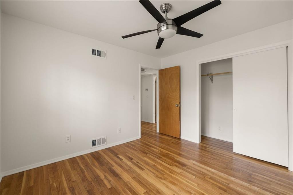 2941 Caldwell Road Northeast, Unit B4 Brookhaven, GA 30319 - Photo 27 of 51 an empty room with wooden floor and a ceiling fan