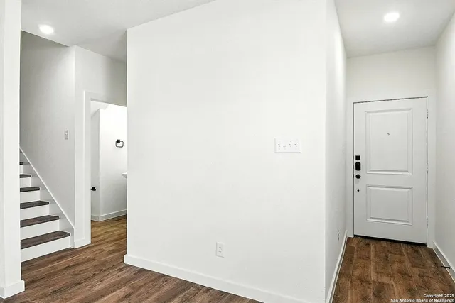 a view of a hallway with wooden floor and entryway