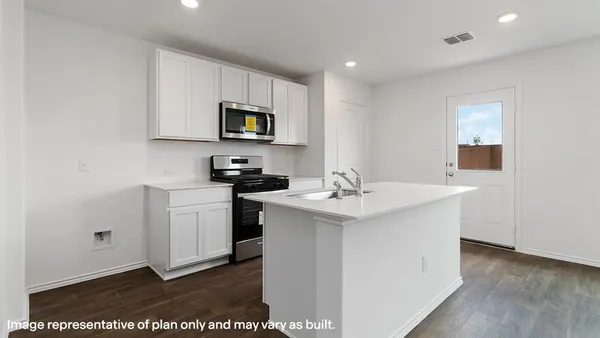 a kitchen with stainless steel appliances granite countertop a sink a stove a microwave a sink a refrigerator and white cabinets