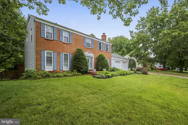 a front view of a house with a yard and trees