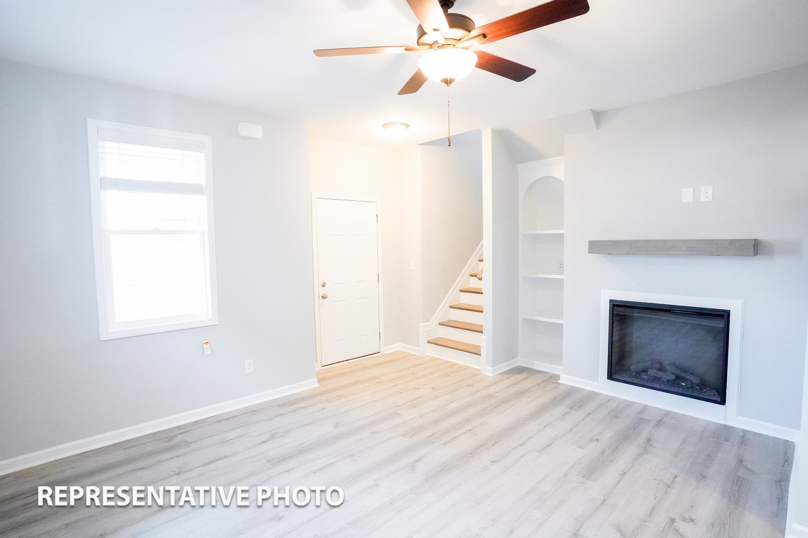 148 Longbow Drive Middlesex, NC 27557 - Photo 5 of 9 an empty room with wooden floor fireplace and windows
