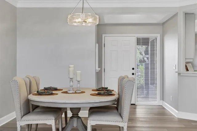 a view of a dining room and livingroom with furniture wooden floor and a chandelier