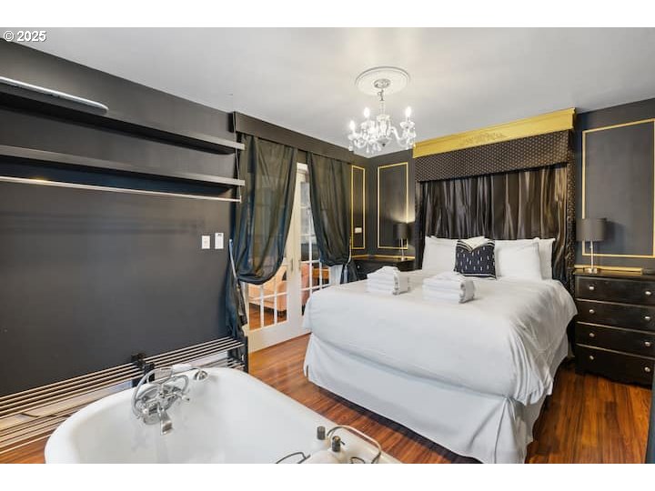 610 West Fourth Plain Boulevard Vancouver, WA 98660 - Photo 14 of 41 a bedroom with a bed and a chandelier