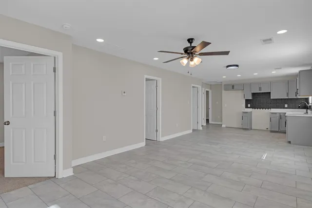 a view of a kitchen with a sink and a chandelier fan