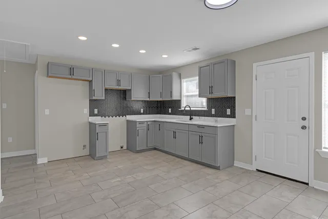 a kitchen with white cabinets stainless steel appliances and a sink
