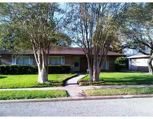 a front view of a house with a yard and an tree