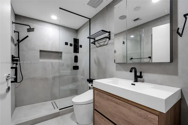 a bathroom with a sink a toilet and shower