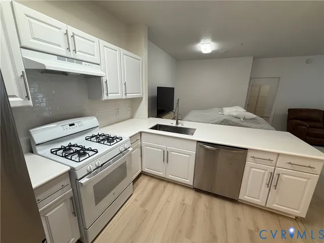 a kitchen with cabinets appliances and a counter space