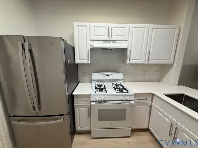 a kitchen with refrigerator a stove and cabinets