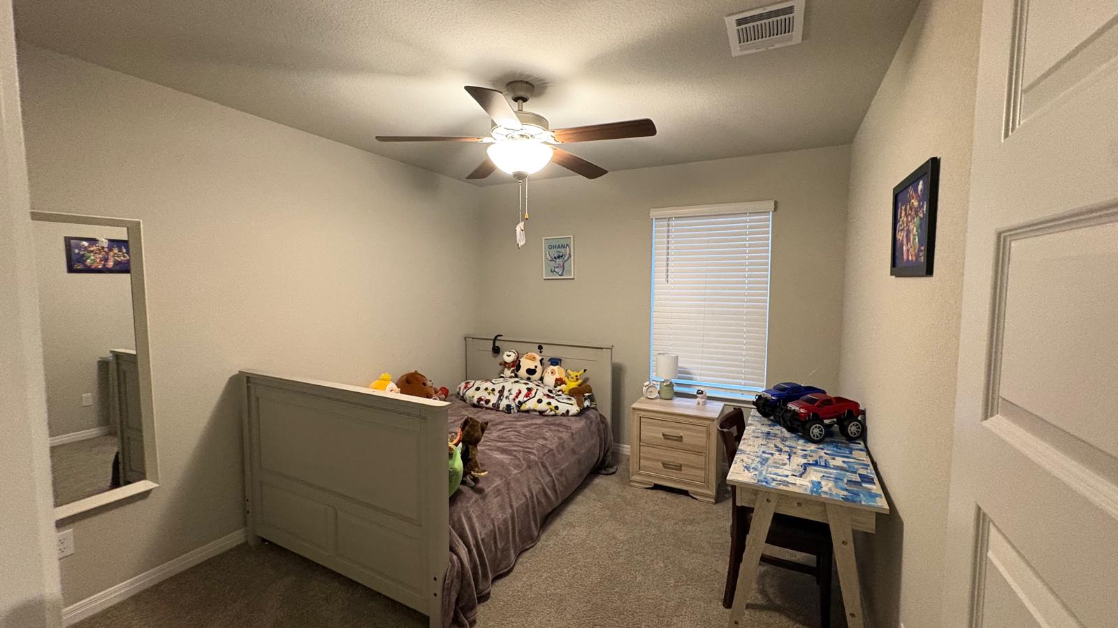 6511 Dragride Road Buda, TX 78610 - Photo 21 of 36 An inviting bedroom with plush carpeting and a modern ceiling fan for year-round comfort.