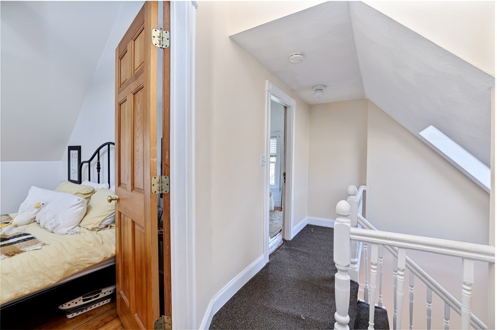 24-26 Crescent Street Cambridge, MA 02138 - Photo 11 of 36 a view of a hallway with bed and wooden floor