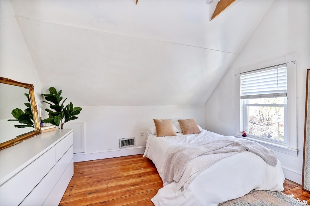 24-26 Crescent Street Cambridge, MA 02138 - Photo 13 of 36 a bedroom with a large bed and a potted plant
