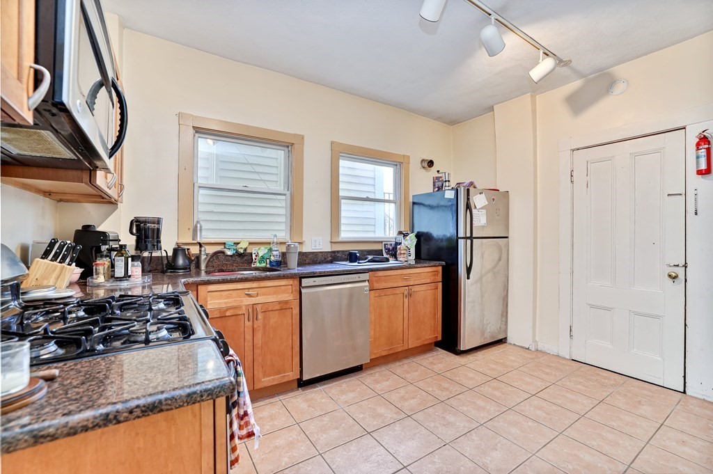 24-26 Crescent Street Cambridge, MA 02138 - Photo 24 of 36 a kitchen with stainless steel appliances granite countertop a stove a refrigerator and a sink