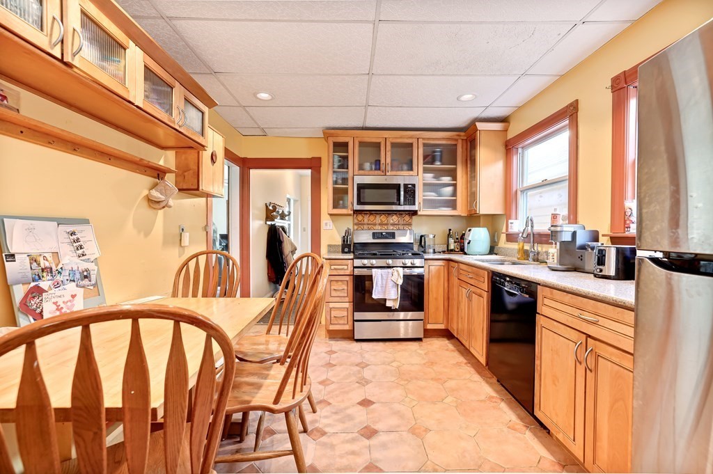 24-26 Crescent Street Cambridge, MA 02138 - Photo 6 of 36 a kitchen with stainless steel appliances granite countertop a refrigerator a sink dishwasher a stove and a dining table with wooden floor