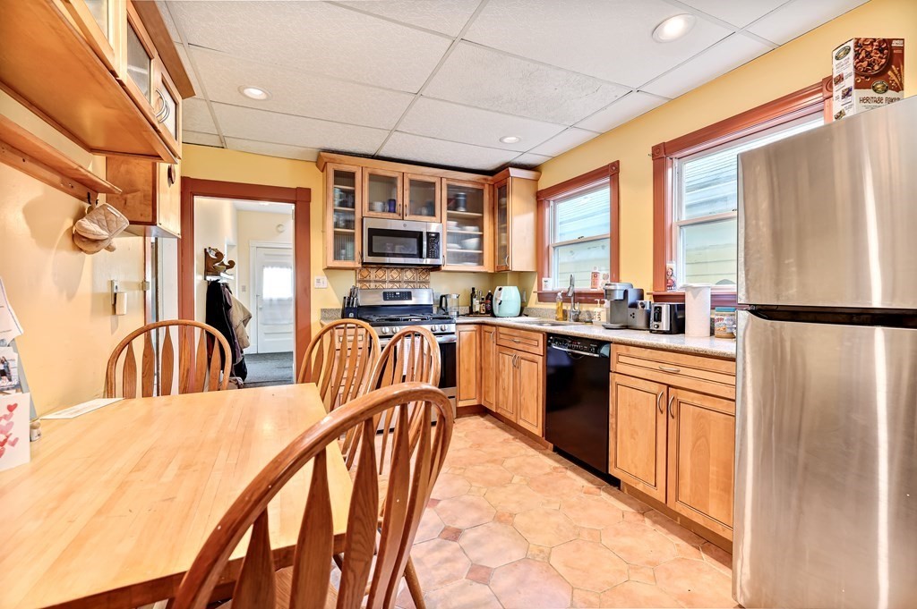 24-26 Crescent Street Cambridge, MA 02138 - Photo 7 of 36 a kitchen with stainless steel appliances granite countertop a refrigerator a sink a stove and white cabinets with wooden floor