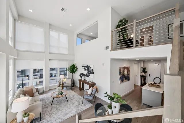a living room with furniture a rug and a potted plant